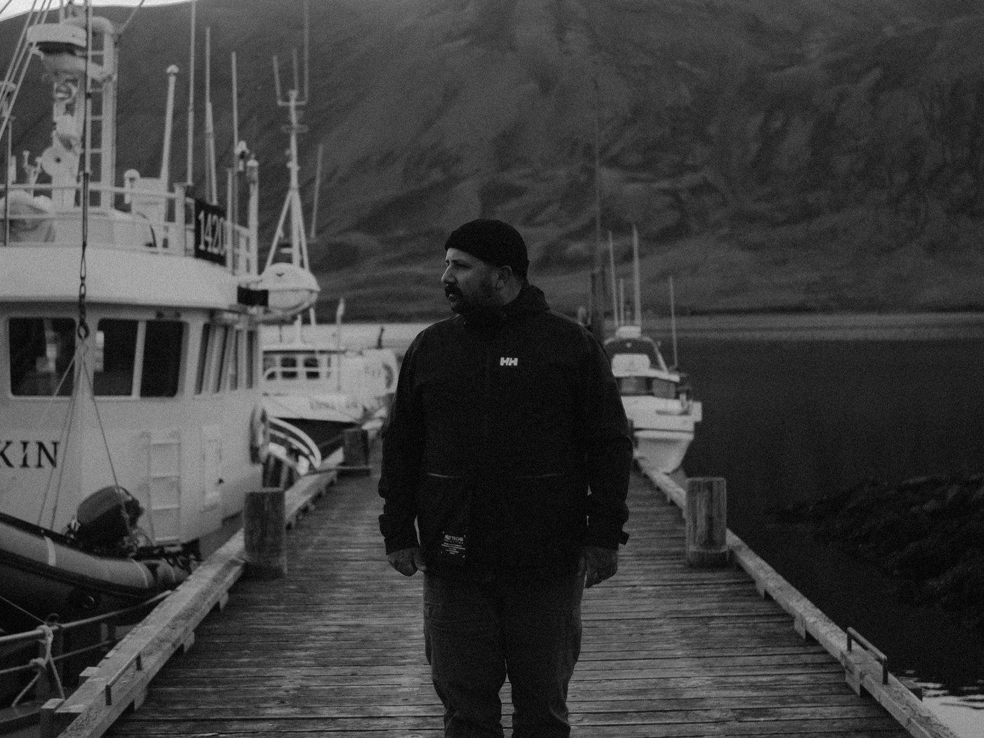 Yanick Lesperance standing on a harbour dock, black and white